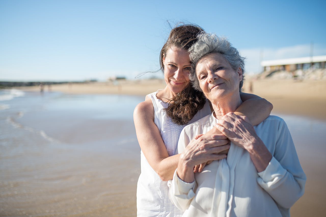 Services Heartwarming photo of mother and daughter embracing on a sunny Portuguese beach.